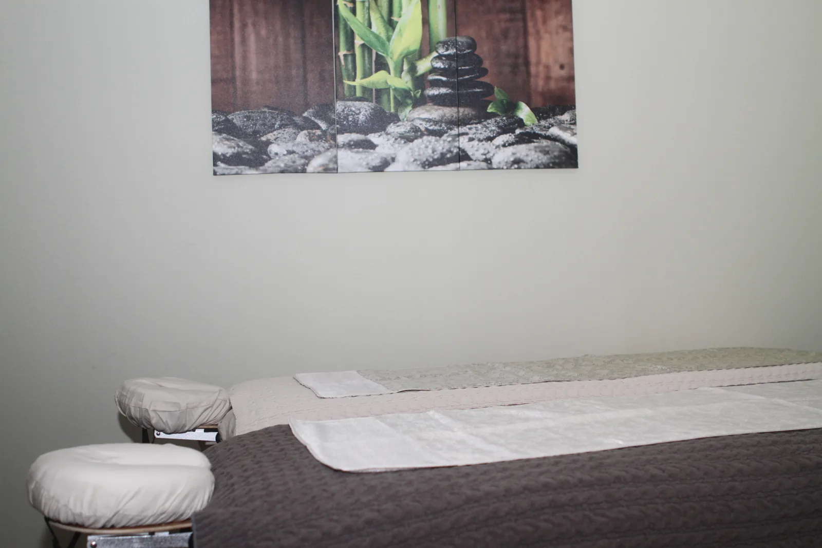 Single treatment room with massage table and bamboo artwork
